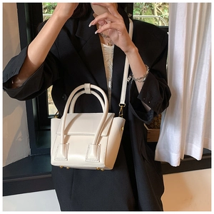 Vue détaillée des rivets métalliques sur le fond du sac à main en cuir blanc crème