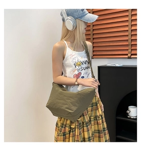 Detail view of the olive green canvas dumpling bag with stylish pleated shoulder strap