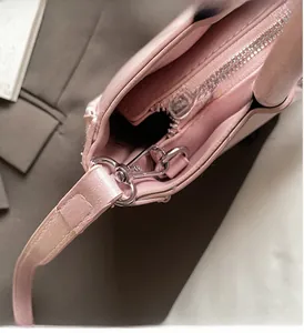 Detailed close-up of pink bucket bag with silver zippers and metal D-ring hardware