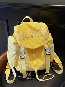 Minimalist bright yellow nylon backpack with multi-pocket design and buckle strap accents