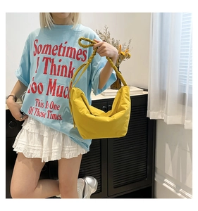 Detail of a bright yellow crescent hobo bag featuring a stylish scrunchie shoulder strap