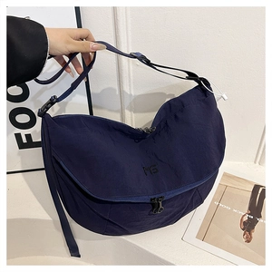 Detailed shot of dark blue nylon crossbody bag with adjustable strap and zip closure