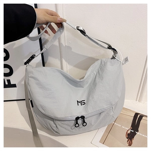 Detail of light grey nylon crescent bag showing MS logo and adjustable buckle strap