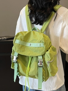 Green nylon backpack for women featuring drawstring closure and silver metal buckles