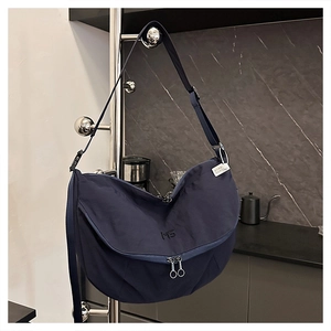 Detailed view of the navy blue crescent tote with dual zippers and MS logo embroidery