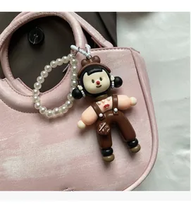 Detailed macro view of trendy 3D doll bag charm with white pearl chain accessory