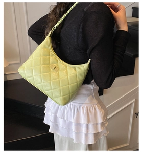 Neon green quilted leather half-moon shoulder bag shown on a model in a casual setting