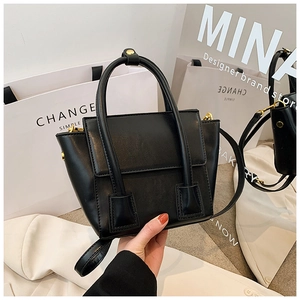 Vue détaillée du sac seau en cuir noir avec ferrures dorées élégantes et finition mate lisse
