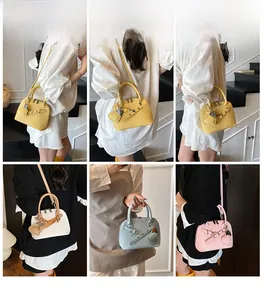 Detailed views of multi-color shell handbags featuring litchi grain leather and heart charms