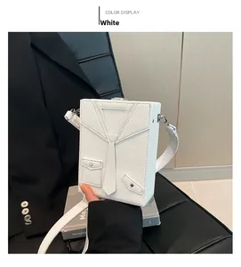 Detail of white blazer-shaped box bag with tie decor and pebbled leather texture