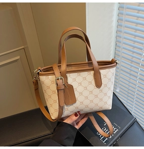 Détail du sac cabas en toile monogramme crème avec anses en cuir marron et bandoulière