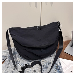 Detail of black nylon tote bag with embroidered MS logo and adjustable strap