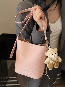 Pink lychee grain leather bucket bag with cute teddy bear charm for women's crossbody wear