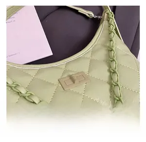 Detail showing mint green quilted leather texture and turn-lock closure on shoulder bag