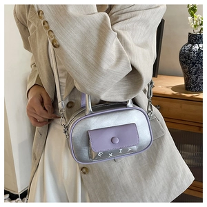 Detail der silbernen Metallic-Ledertasche mit lila Tasche und EXIT-Schriftzug