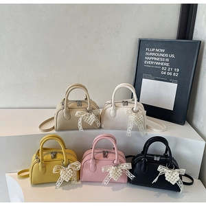 Dettaglio di mini borse in pelle di lusso in cinque colori con ciondoli in pizzo e perle