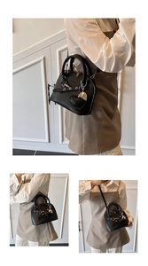 Close-up of black lychee texture shell bag with silver hardware and heart charm detail