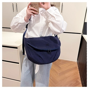 Detail of navy nylon crossbody bag featuring an adjustable strap and MS logo embroidery