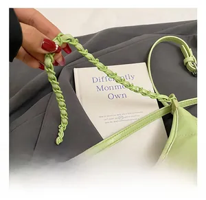 Detail of light green quilted bag showing the woven handle and classic lock closure