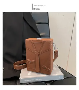 Detailed close-up of a brown suit-style box bag with 3D tie design on a book