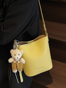 Chic yellow lychee pattern leather bucket bag with teddy bear charm for women