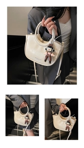 Detail of cream crescent bucket bag with leather texture and cute doll pendant charm