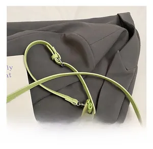 Detail showing the adjustable light green faux leather strap with silver buckle on a shoulder bag
