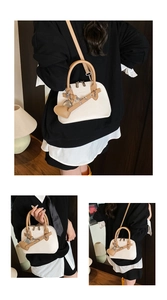 Detail of shell-shaped handbag in beige and camel leather with heart pendant and chain