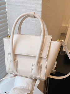 Sac seau chic blanc crème avec poignées et détails dorés présenté dans un décor moderne