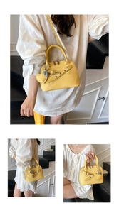 Detail view of yellow shell-shaped handbag with litchi grain and heart charm