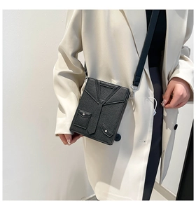 Detail of creative suit-style box bag with tuxedo lapel and tie design in black leather