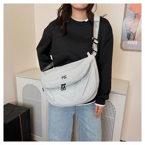 Close-up of light grey nylon crossbody bag featuring double rings and MG logo