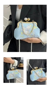 Close-up of exquisite floral embroidery and dual pearl straps on light blue satin bag