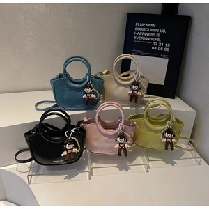 Group of vibrant leather bucket bags with cartoon doll charms and pearl chain decor