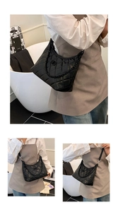Detail of black quilted hobo bag with diamond stitching and elegant metal chain