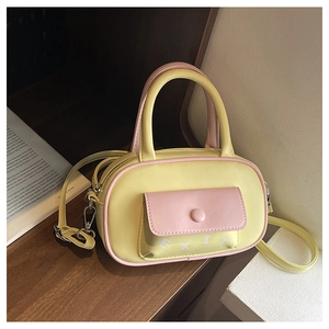 Detail einer Mini Boston Bag in Gelb und Rosa mit EXIT Schriftzug und Silberbeschlag