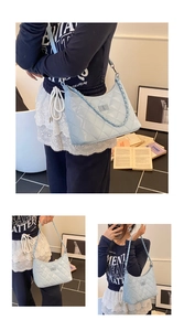 Close-up of light blue quilted shoulder bag with chain strap and metallic lock detail