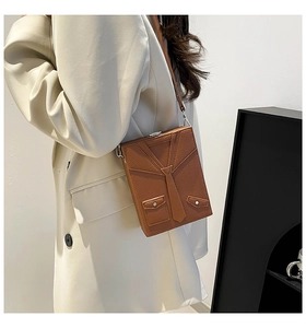 Detailed view of brown box-shaped crossbody bag with creative necktie and pocket design