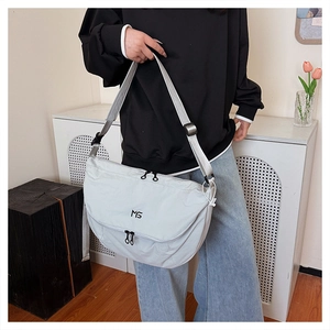 Detail view of light grey nylon crossbody bag with MS logo and adjustable shoulder strap