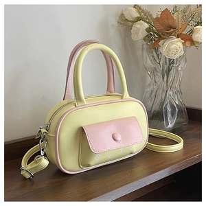 Detail der gelb-rosa Boston Bag mit weißem EXIT-Logo und praktischer Vordertasche