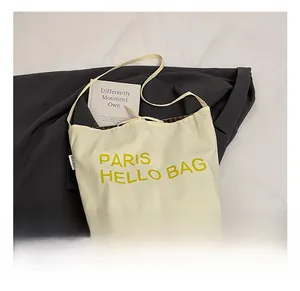 Detailansicht beige Canvas-Einkaufstasche mit Paris Hello Bag Aufdruck und Karofutter