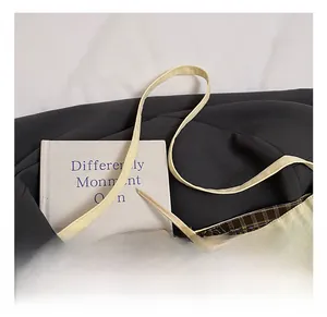 Detailaufnahme der beigen Canvas-Tasche mit gewebten Tragegriffen und braunem Karofutter