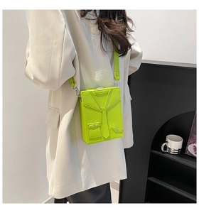 Detail of neon green box bag with a unique suit and tie design and silver hardware