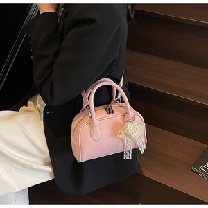 Borsa Boston rosa a grana di litchi con fiocco di perle e pizzo indossata da modella