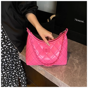 Detail of rose pink quilted leather handbag with woven chain strap and turn-lock