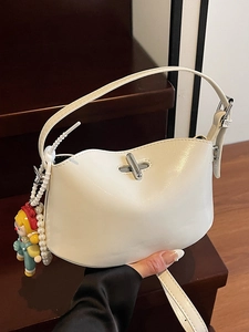 Minimalist beige oil wax leather crescent handbag with silver swivel lock and charms