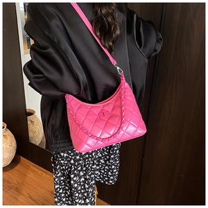 Rose pink quilted chain bag worn by a model in a stylish street style setting