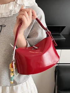 Elegant red faux leather handbag with silver twist lock and pearl doll charm accessory