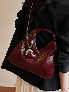 Minimalist wine red triangle handbag with metallic heart charm and silver chain strap