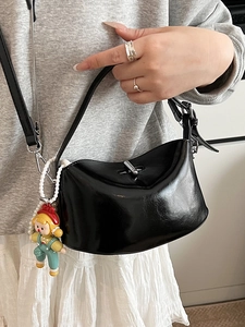 Chic black glossy oil wax leather crescent handbag with a decorative bead charm